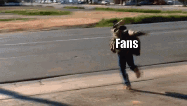 a person is running down a street with the word fans on their back