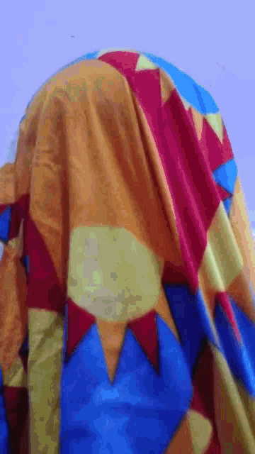 a close up of a colorful blanket with a blue triangle in the middle
