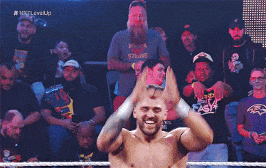 a man wearing a shirt that says strong is standing in front of a crowd