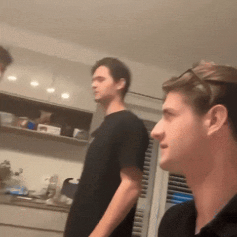 a man in a black shirt is standing next to another man in a black shirt