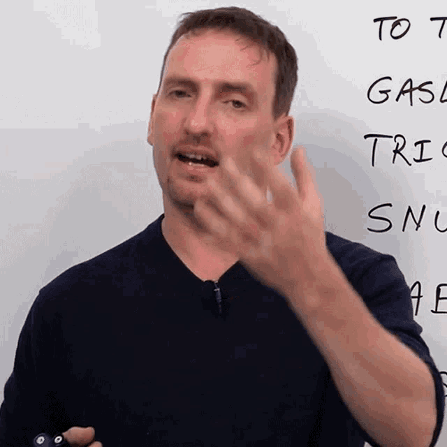 a man stands in front of a white board that says to t