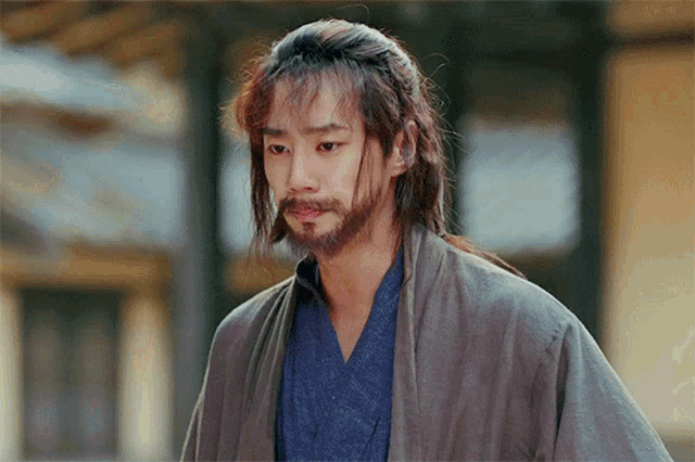 a man with a beard is wearing a kimono