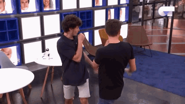 a man in a black shirt is standing next to another man in a white shirt