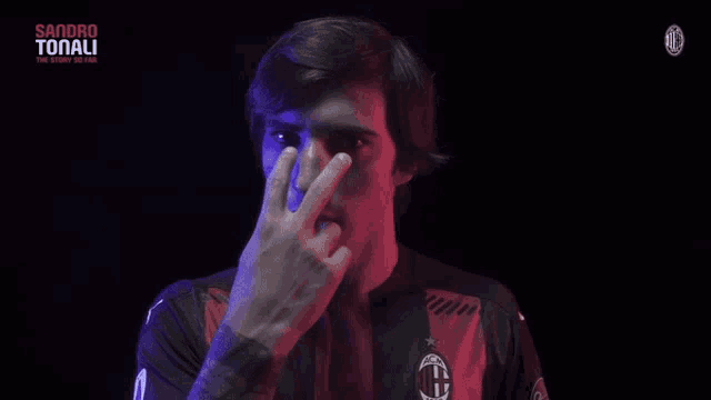 a man in a dark room with the word tonali on the top