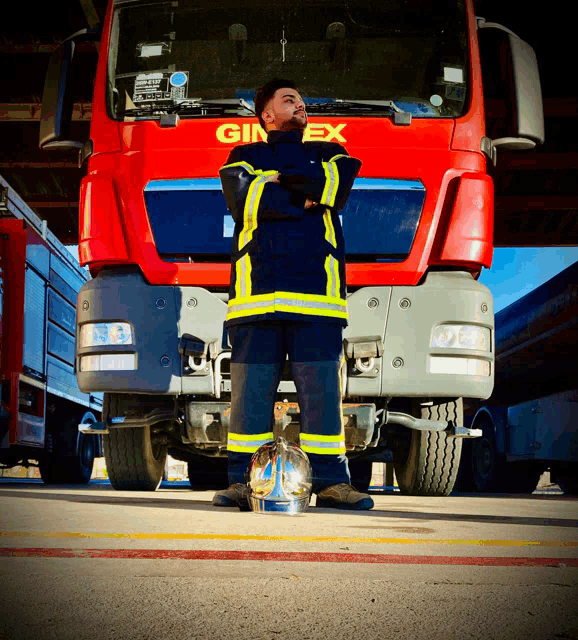 a fireman stands in front of a red ginex truck
