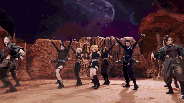a group of women are dancing in front of rocks