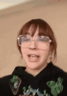 a woman wearing glasses is making a funny face .