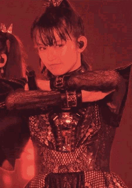 a girl with a ponytail and a crown on her head is dancing in a dark room