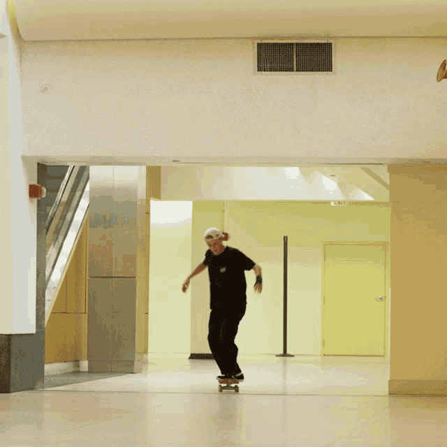 a person riding a skateboard in a hallway with an exit sign