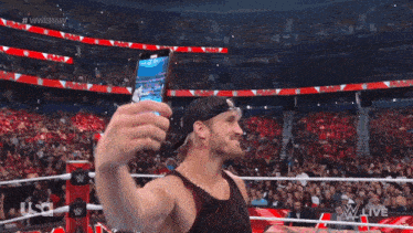 a man taking a picture of himself in a wrestling ring with the words #wweraw behind him