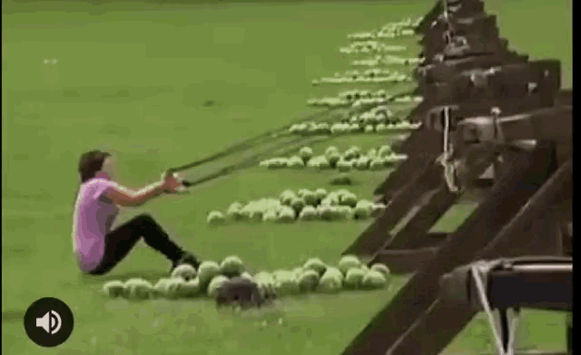 a woman is sitting on the ground holding a slingshot in front of a pile of watermelons .