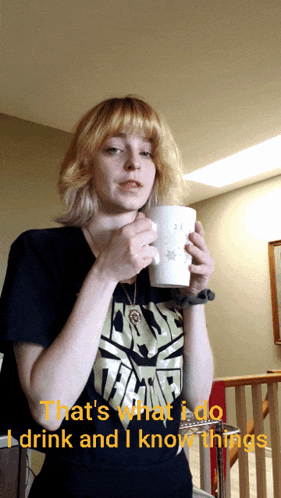 a woman in a star wars shirt drinks from a cup