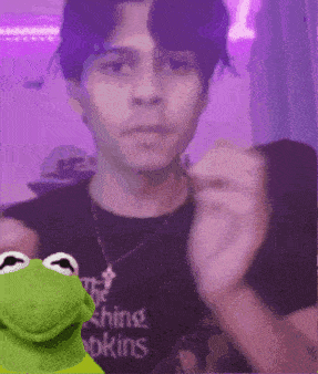 kermit the frog is standing next to a man wearing a t-shirt that says the shining bookins