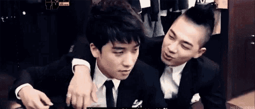 two men in suits and ties are hugging each other and one has his arm around the other 's shoulder