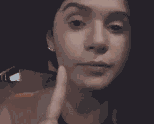 a close up of a woman making a face with her hand on her chin