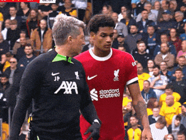 a man in an axa jersey talks to a man in a red shirt