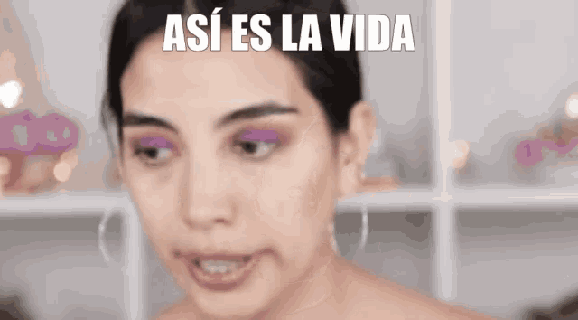 a woman with purple eyeshadow and the words así es la vida on her face