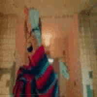 a man in a striped sweater is brushing his teeth in front of a mirror .