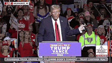 donald trump is giving a speech in front of a crowd of supporters .