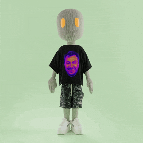 a stuffed toy wearing a black t-shirt with a man 's face on it