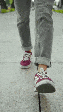 a person wearing a pair of purple and white sneakers