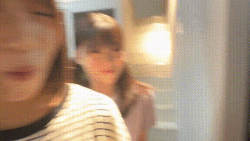 a blurry picture of two women standing in a hallway
