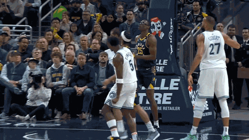 a basketball player with the number 27 on his jersey stands on a court