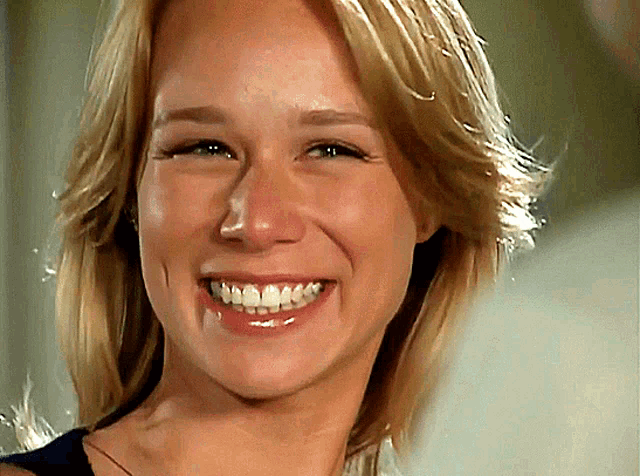 a close up of a woman 's face smiling with her mouth open