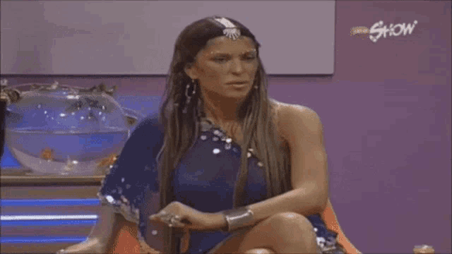 a woman sitting in front of a sign that says show on it