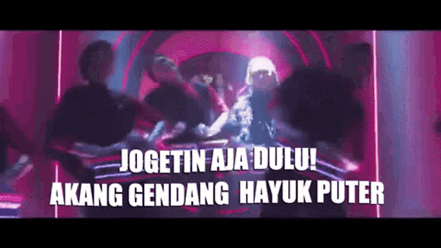 a group of people are dancing in a dark room with the words jogetin aja dulu !