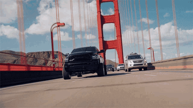 a black truck is driving over a bridge