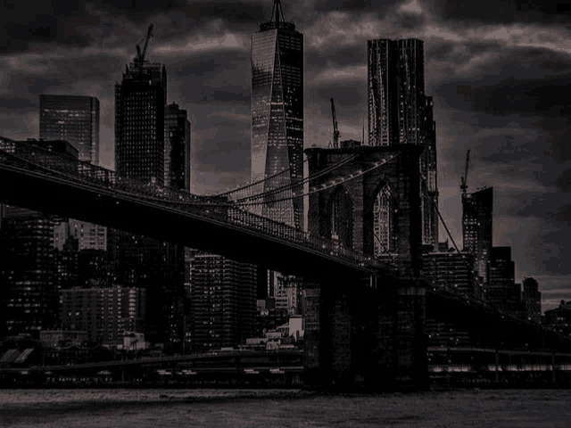 a bridge over a body of water with a city skyline behind it