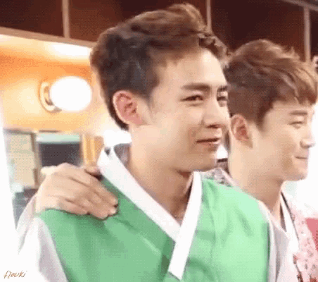 two young men are standing next to each other and one of them is wearing a green kimono ..