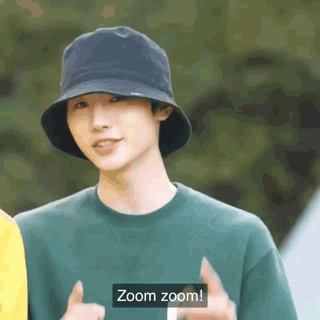 a man wearing a bucket hat and a green shirt says zoom zoom