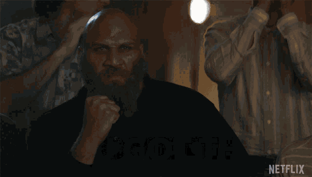 a man with a beard holds his fist in the air and says you got this