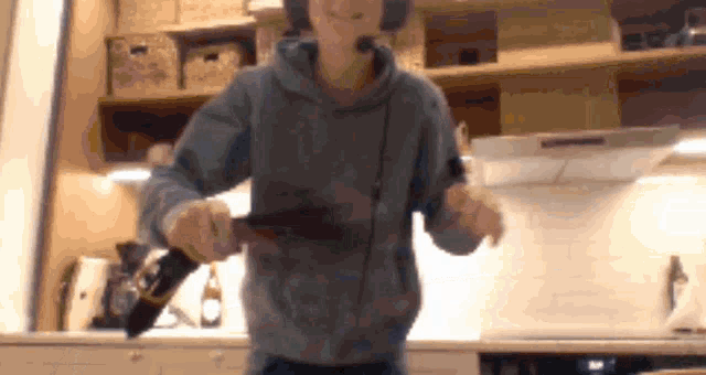 a man wearing a headset is holding a bottle of beer