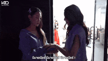 two women standing next to each other with ktd on the bottom right