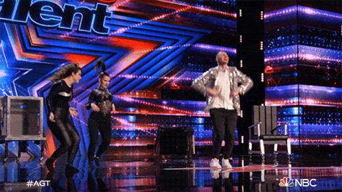 a group of people are dancing on a stage in front of a sign that says talent on it