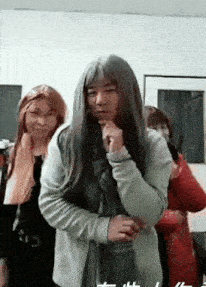 a man with long hair is standing next to a woman with long hair .
