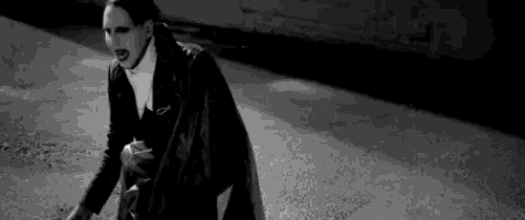 a black and white photo of a man wearing a mask .