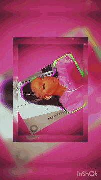 a woman in a pink hoodie is sitting in front of a pink wall .