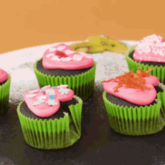 a bunch of cupcakes with pink frosting and sprinkles on them