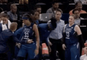 a group of basketball players are standing next to each other in a stadium .
