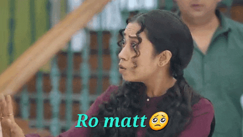 a woman with curly hair is making a funny face and the words ro matt are above her head .