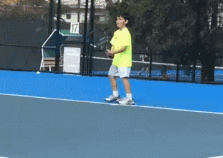 a young boy playing tennis on a court with the number 17 behind him