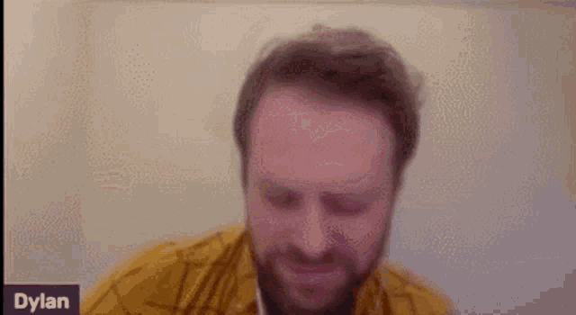 a man with a beard is making a funny face in a video call .