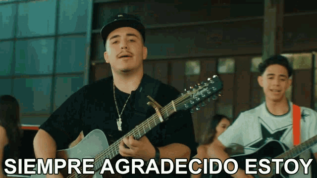 a man playing a guitar with the words siempre agradecido estoy written below him