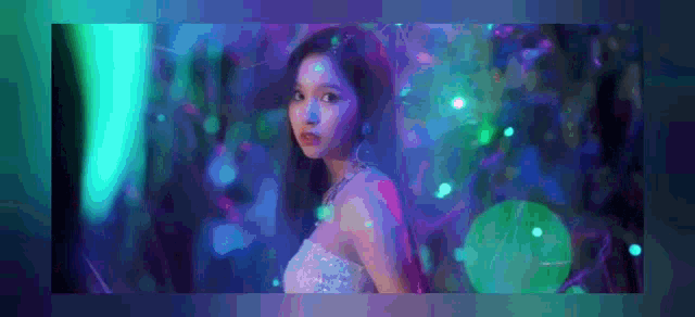 a woman in a white dress is standing in a dark room with a lot of lights on .