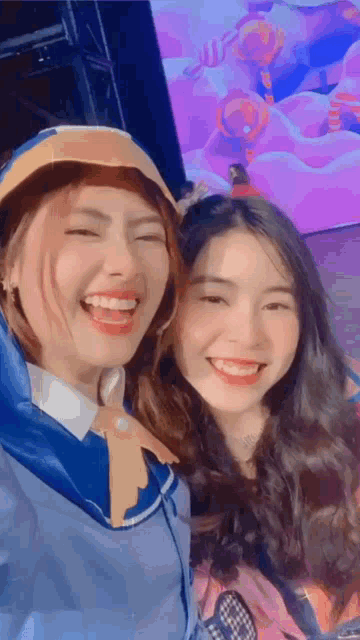 a couple of girls are posing for a picture together and smiling .