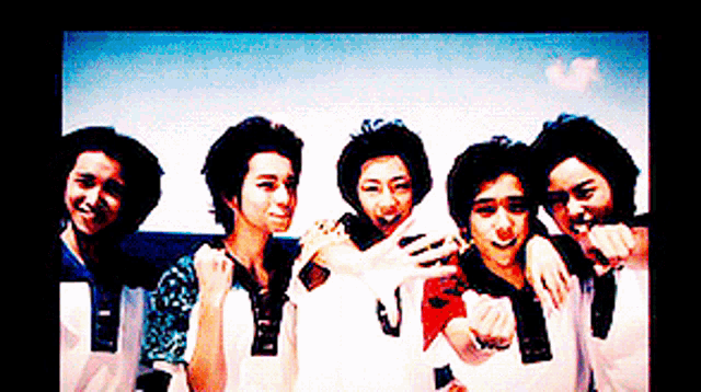 a group of young men are posing for a picture and one of them is wearing a shirt that says ' a '
